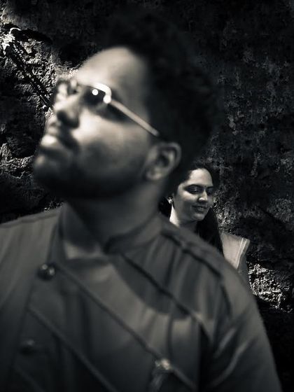 A moody and artistic black and white portrait. The selective focus and dramatic lighting create a sense of depth and emotion.