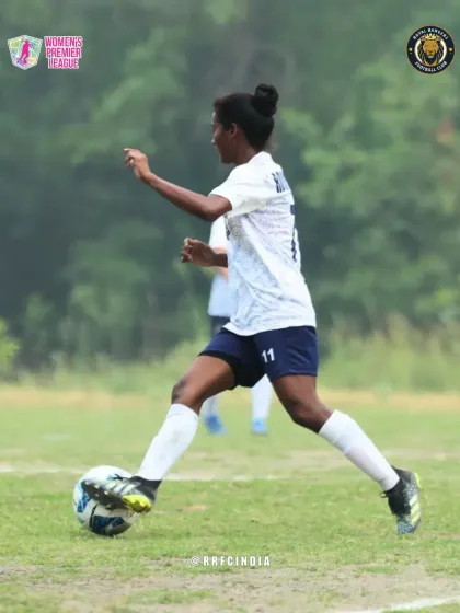 A player in our white kit dribbles the ball with precision and focus, looking for an opening in the opponent's defense.