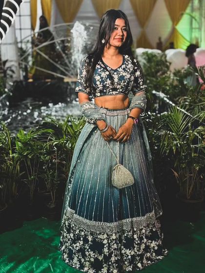 Another look at our client enjoying her event in the blue ombre lehenga. The floral blouse adds a touch of freshness to the glamorous look.