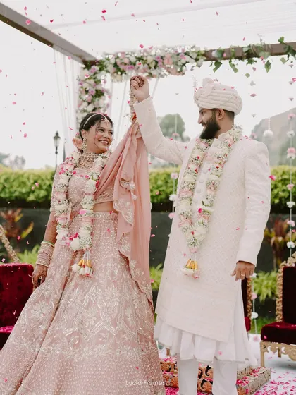 A dance of joy after exchanging garlands. We capture the candid happiness that follows traditional wedding rituals.