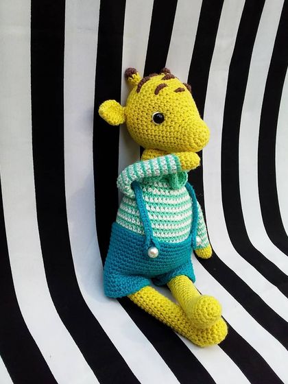 George the giraffe sitting down. His long legs and neck were fun to crochet, and I love how his outfit turned out.
