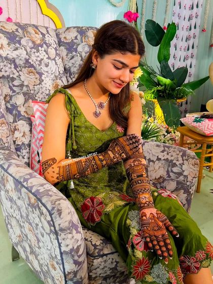A candid shot of a bride admiring her beautiful, detailed henna design.