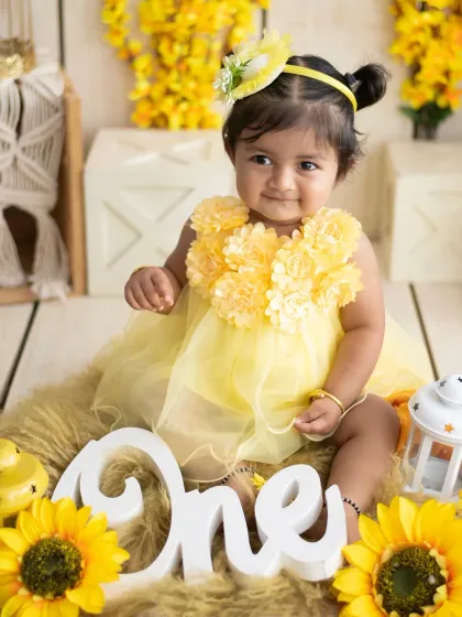 A beautiful portrait of the birthday girl in her sunflower dress, surrounded by cheerful yellow flowers.