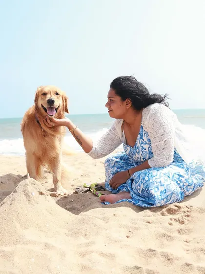 A beach day with your best friend is pure happiness. I love capturing the special bond between pets and their parents in beautiful outdoor settings like this. This golden retriever is sharing a quiet, sandy moment with his mom.