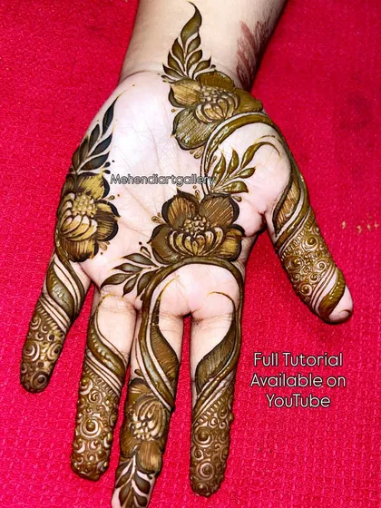 A striking Arabic floral design on the palm. The use of negative space makes the shaded flowers and swirling finger patterns pop. A full tutorial for this design is available on my YouTube channel.