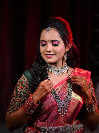 A candid moment of Disha adjusting her necklace, giving a great view of her intricate jewellery and makeup.