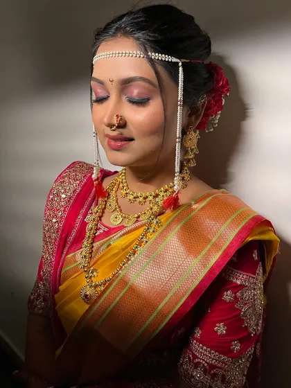 A detailed shot of the bridal makeup, focusing on the flawless base and soft eyeshadow. The traditional bindi and nath complete this classic Maharashtrian look.