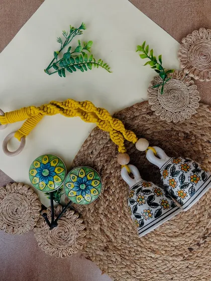 Our 'Green Quoted Combo' is perfect for plant lovers. This set includes two yellow macrame bells, four green glass frames with quotes, a wooden plank, and two ceramic hooks to complete the look.