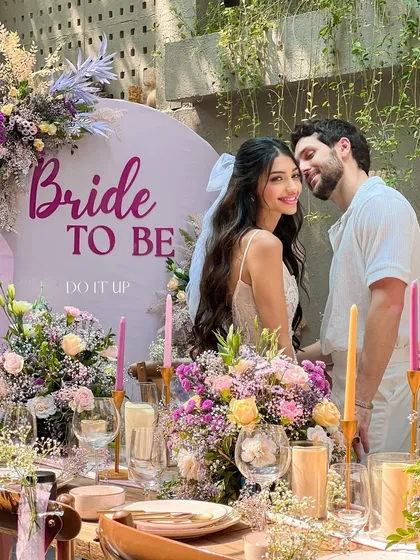 A beautiful 'Bride to Be' shower. The tablescape is filled with lush florals in shades of purple and pink, creating a romantic and celebratory setting for the bride and her loved ones.