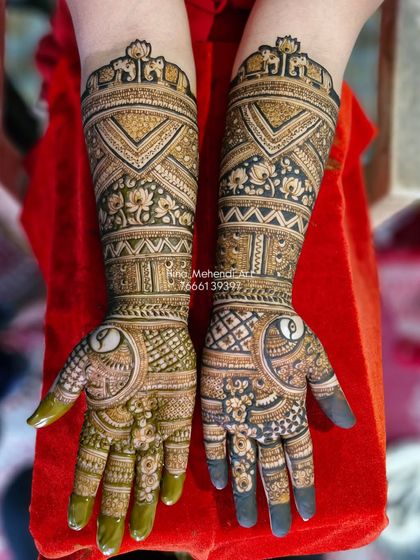 This design features a unique layout with large elephant motifs on the forearms, combined with bold geometric patterns and delicate floral fillers.