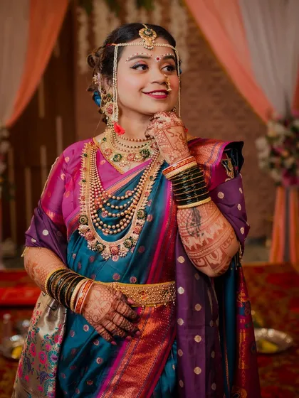 A stunning portrait of a bride in her vibrant Maharashtrian wedding attire. Her confident pose and happy expression perfectly capture the spirit of her special day.