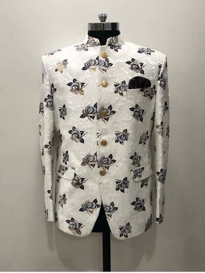 A white Jodhpuri jacket with a sophisticated grey and black floral print, shown on a mannequin. This is a great option for a day event or a sangeet ceremony.
