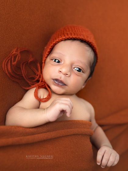 An adorable awake shot of a seven-day-old newborn. His curious eyes and tiny movements are just as precious to capture as the sleepy poses.