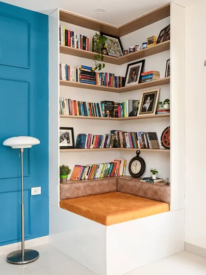 A cozy reading nook built into a home office space. The corner design maximizes the use of space, providing ample shelving for books and a comfortable cushioned bench for hours of reading.