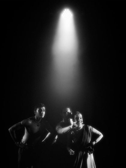 A black and white shot of the 'Nagamandala' cast under a single spotlight. This creates a feeling of suspense and drama, drawing the audience into a pivotal moment.