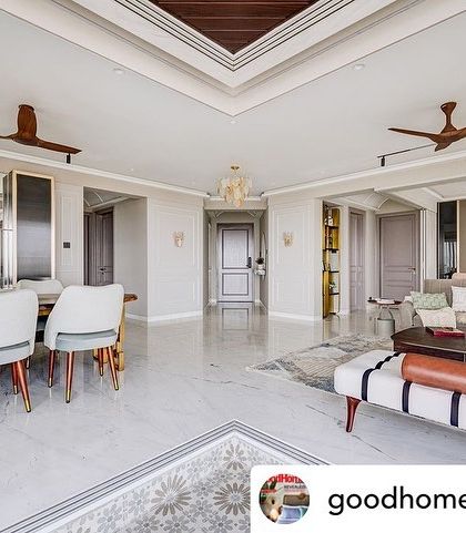 An open-plan living and dining area from a feature in Good Homes Magazine. The cohesive design uses white marble floors and a neutral color scheme to unite the different zones of the home.