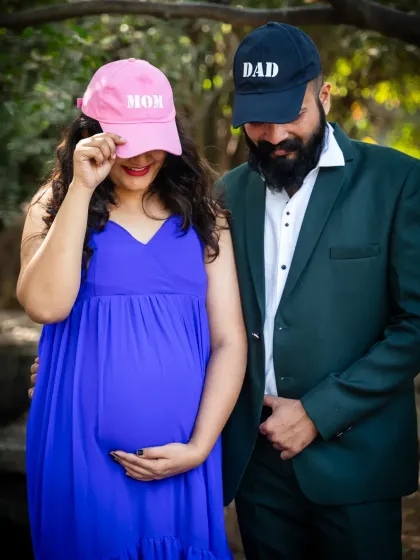 Getting ready for their new roles as "Mom" and "Dad." This playful shot with matching caps is a fun and casual way to capture the excitement.