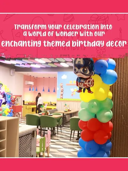 A view of our cafeteria area transformed with a superhero theme, featuring a Captain America balloon column. We ensure the theme carries through the entire party space.