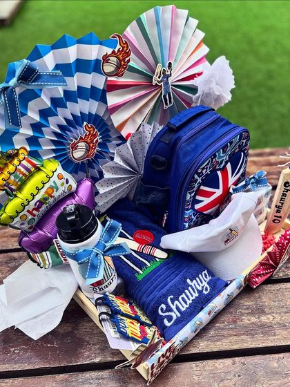 The full cricket hamper, bursting with color, personalized items, and playful details like paper fans and themed cutouts.