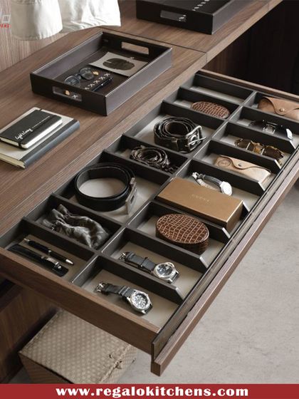 A custom pull-out drawer designed for a gentleman's essentials. It features dedicated compartments for watches, pens, belts, and other personal items.