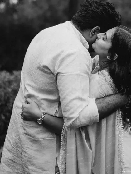 A tender kiss in a quiet moment. The black and white tones add a sense of nostalgia and romance, making this simple gesture feel profound.