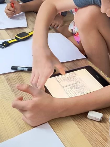 Using a tablet for reference, a student studies the details for his drawing. We integrate technology thoughtfully to support traditional art skills and provide inspiration.