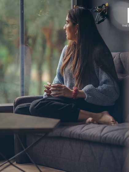 A moment of calm, capturing a person enjoying the view from inside one of our homes, highlighting the connection to nature we strive to create.