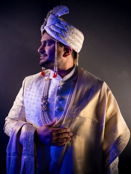 A dramatic portrait of the groom in his sherwani, highlighted by creative spotlighting.