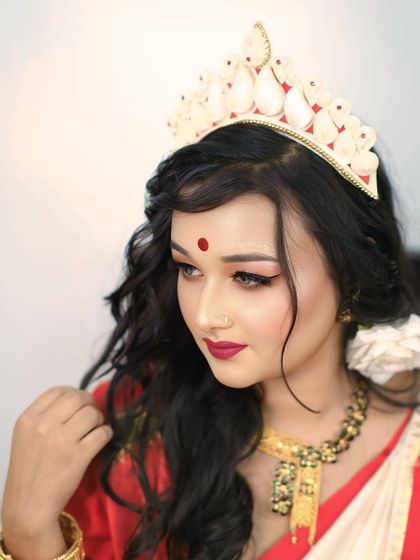 A graceful three-quarter portrait of a model in Bengali bridal attire, capturing her elegant posture and the beauty of her traditional look.