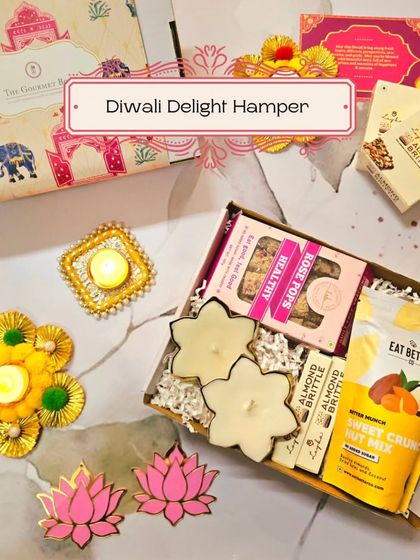 An inviting image of the Diwali Delight Hamper, showing the combination of sweet crunchy nut mix, rose pops, and almond brittle with festive diyas.