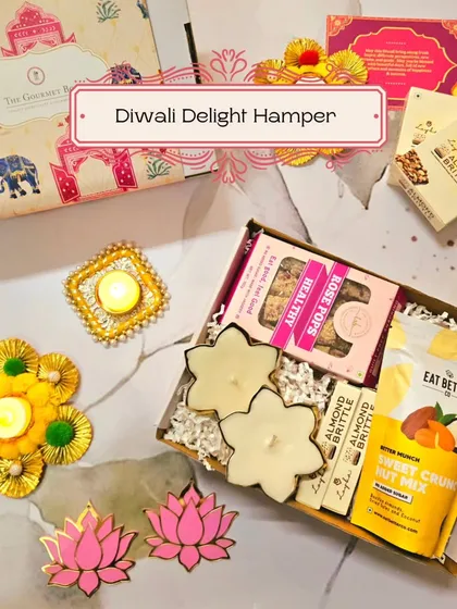 An inviting image of the Diwali Delight Hamper, showing the combination of sweet crunchy nut mix, rose pops, and almond brittle with festive diyas.