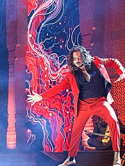 A solo moment in a red suit, capturing the passion and fire of a live performance.