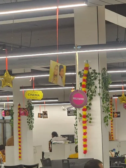 Here is a closer look at the ceiling decorations for the Bollywood party. I used a combination of hanging photos, film-themed signs like "Cinema" and "Bollywood," and traditional flower garlands to create layers of visual interest.