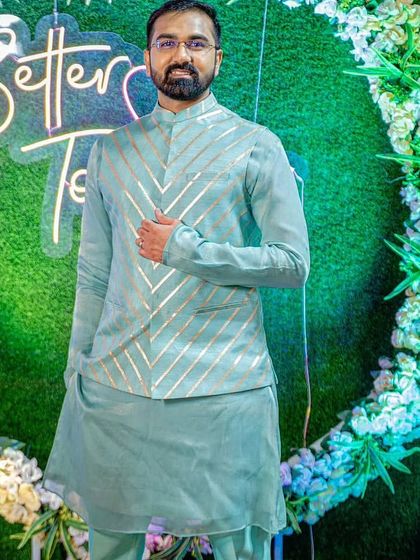 A pastel pista green kurta paired with an organza jacket. The jacket has a modern chevron pattern in silver, adding a touch of contemporary style to the traditional outfit.