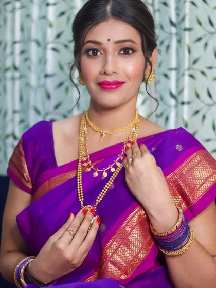 My client looking absolutely regal. The combination of gold jewelry, a bright pink lip, and glowing skin creates a timeless Marathi beauty look.