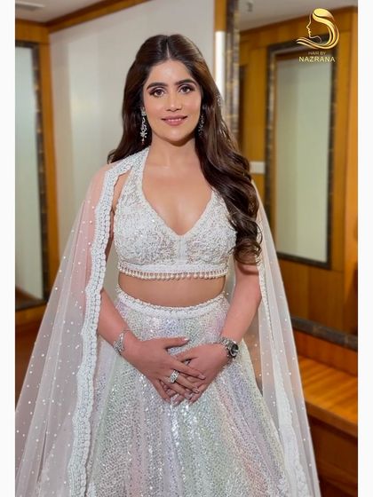 The full look, showing how the soft curls complement her beautiful white lehenga.