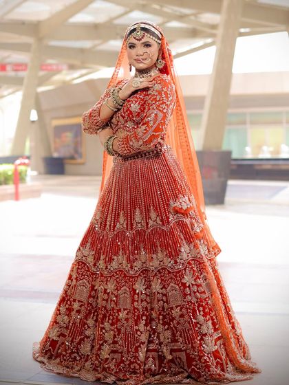 A three-quarter view showcasing the flow of the lehenga and how the complete look comes together. The hair is styled in a classic bridal bun adorned with flowers.