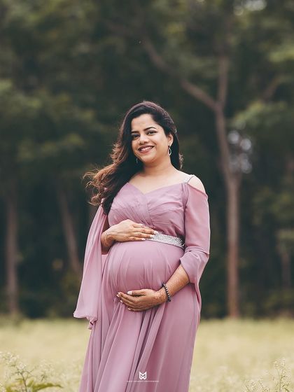 A classic, smiling portrait of the mother-to-be. Her direct gaze and happy expression make for a beautiful and confident shot amidst the natural scenery.