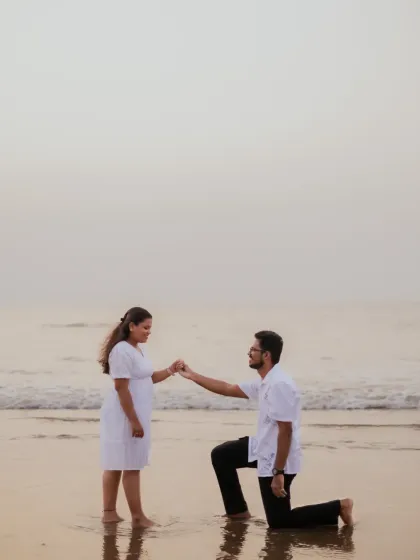 A romantic proposal-style photo on the beach, with the groom-to-be on one knee. This is a beautiful pose to include in a pre-wedding series.