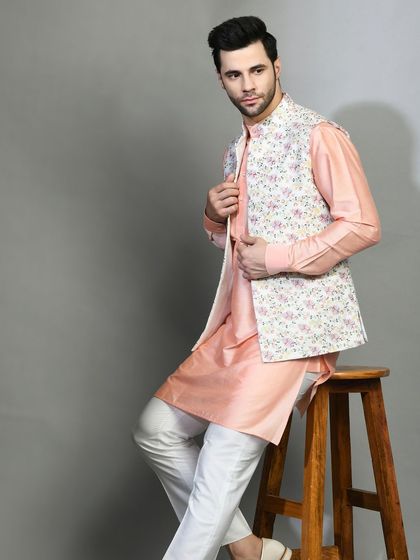 Pastel hues are perfect for summer celebrations. This peach kurta is paired with a floral printed jacket, creating a look that is fresh, modern, and festive.
