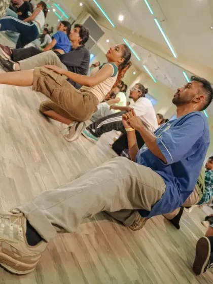 An angled shot capturing the students practicing a groovy move on the floor, led by the instructors.