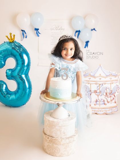 Posing proudly with her third birthday cake, this little princess is the star of the show.