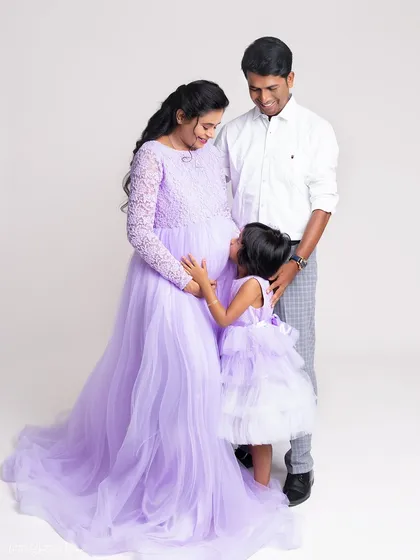An intimate moment during a family maternity shoot. The daughter looks up at her mother's baby bump with so much love and curiosity, a perfect memory to cherish.