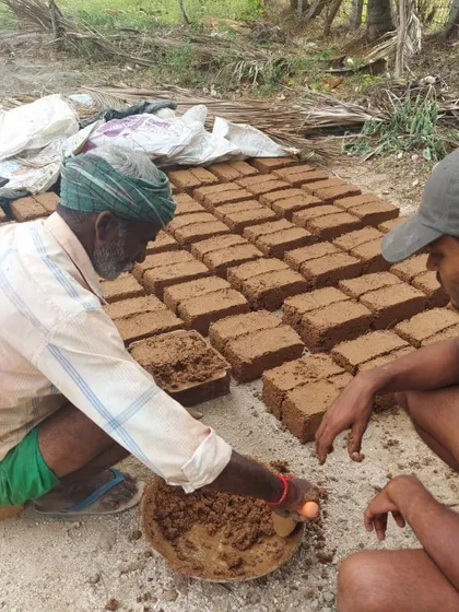 Our owner-builder model involves training local masons in natural building techniques. Here, one of our architects works alongside a mason, teaching him how to form adobe mud bricks by hand.