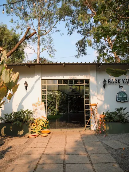 The entrance to Backyard during a sunny Haldi ceremony. The space is filled with natural light, making it bright and cheerful for daytime events.