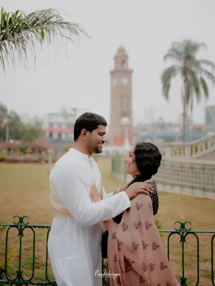 A couple shares a look in front of Mysore's iconic clock tower, blending their story with the city's landmarks.
