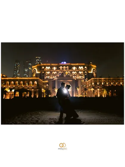 A stunning silhouette against the illuminated Emirates Palace at night. This dramatic, backlit shot is the definition of an epic and glamorous pre-wedding portrait.