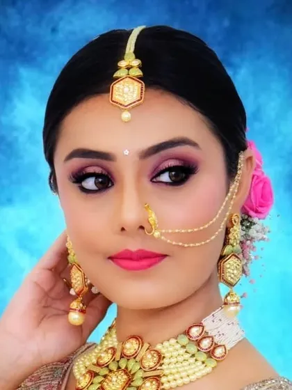 A close-up of the client's beautiful makeup and the floral details in her hair. The sleek bun ensures that all the focus is on her face and accessories.