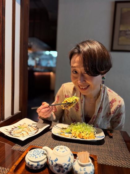 A happy guest enjoying her meal. Seeing our guests delight in the flavors we create is the greatest reward for our team.
