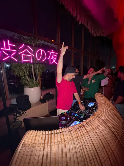 Hands in the air at Megumi, Mumbai. The rooftop view and the neon lights created an incredible atmosphere.